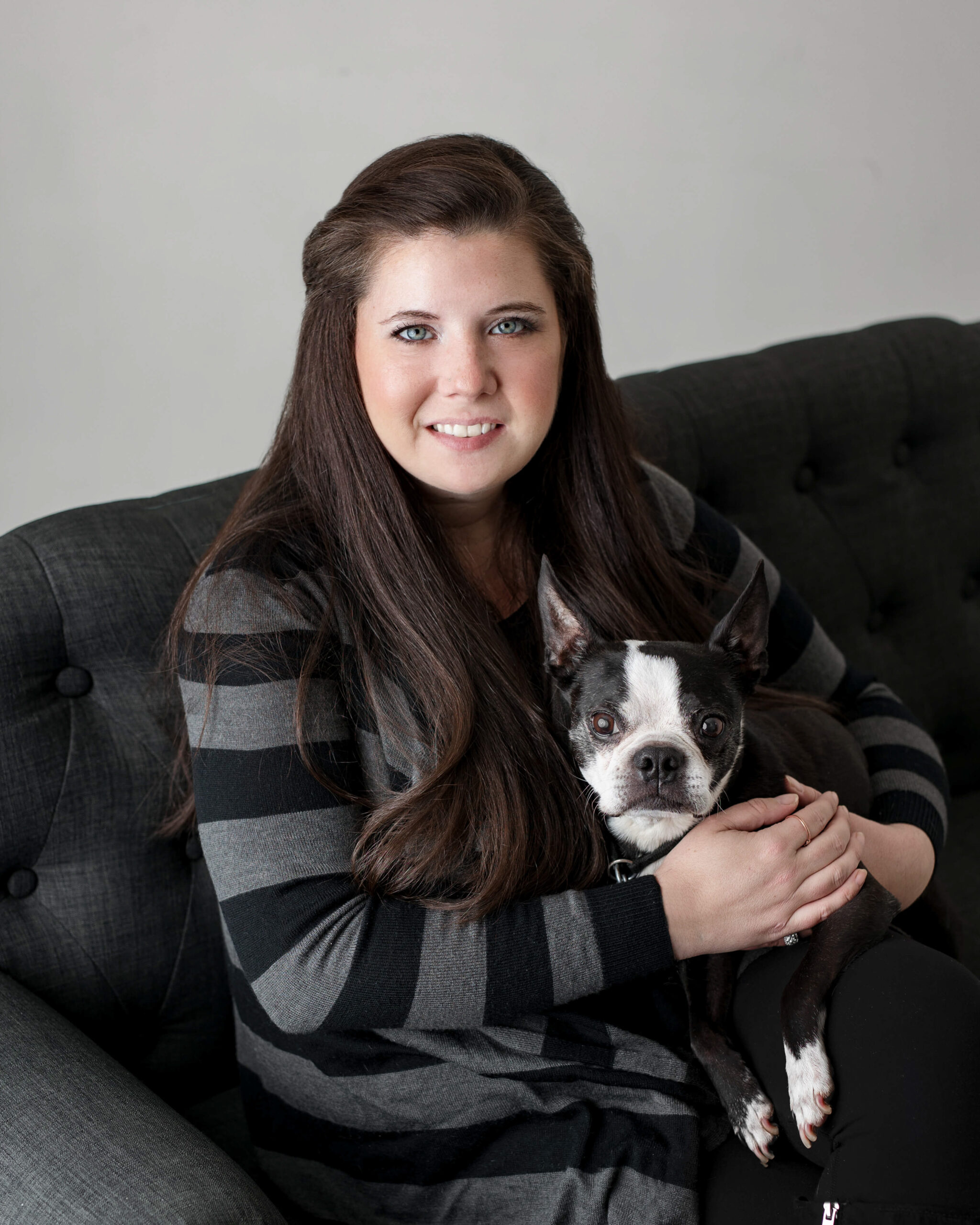 Newborn Photographer in Northern Virginia in her portrait photography studio holding her dog.