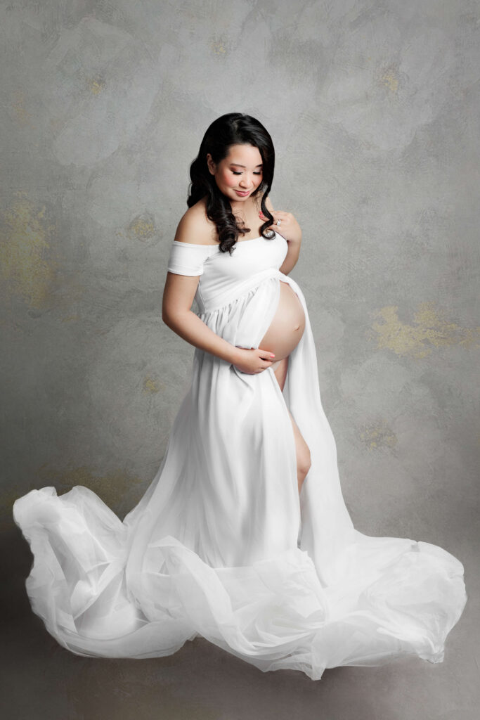 pregnant mother in a white gown studio creative Maternity photoshoot reston va