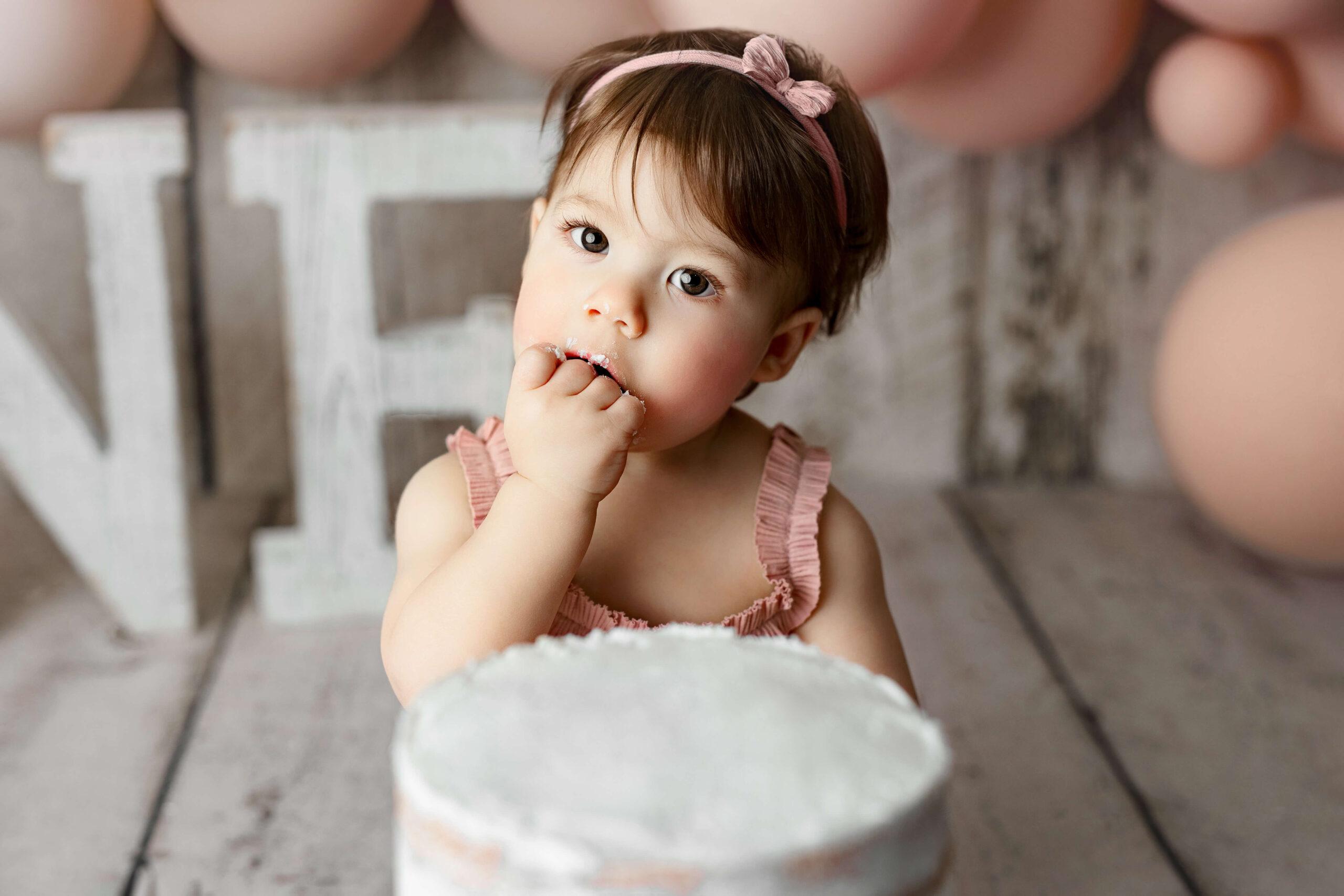 toddler eating cake at her cake smash phoogrqaphy session by a leesburg va toddler photogapher
