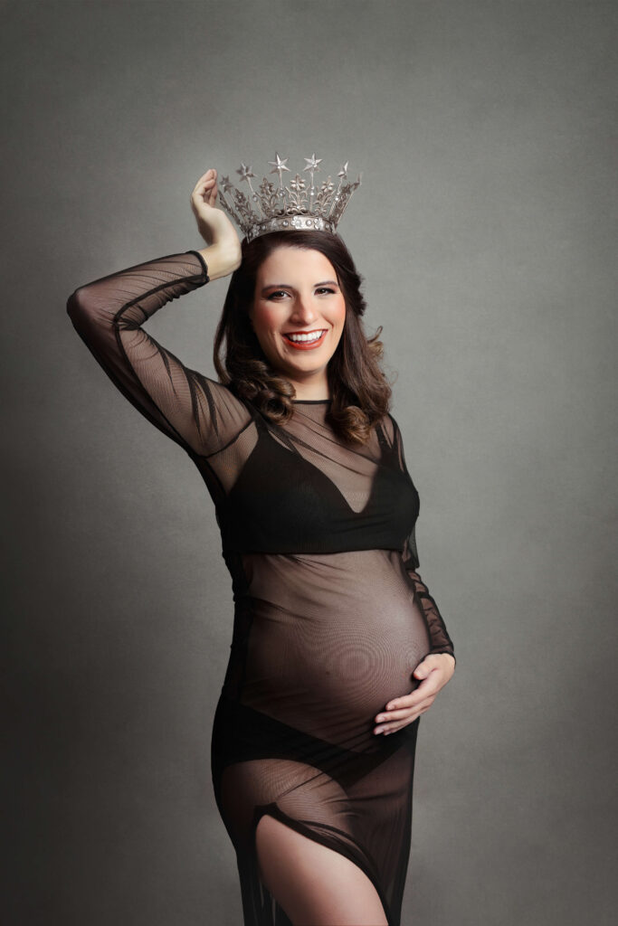 pregnant mother wearing a black gown holding her crown at her northern va maternity session by Maternity Photographer Tysons Corner VA