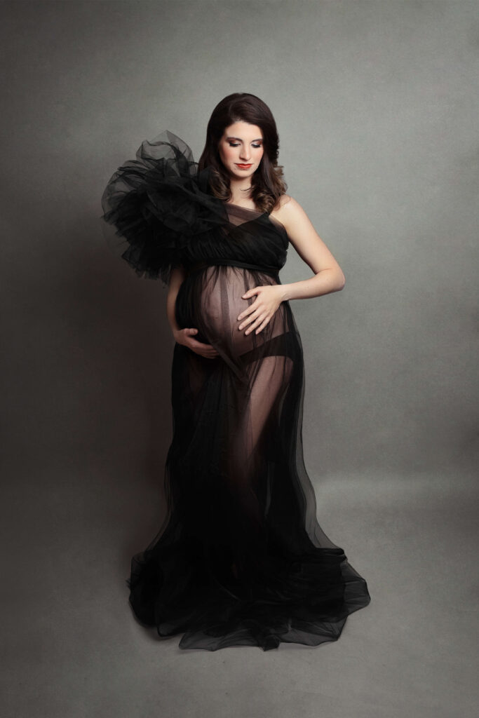 pregnant woman wearing tulle black dress at her session 