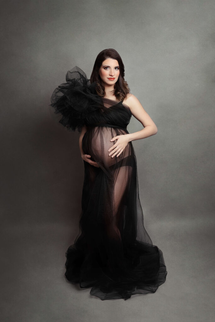 pregnant woman wearing tulle black dress at her studio maternity session 