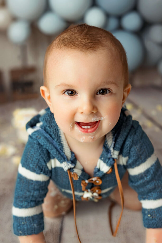 one year old playing with cake at his first birthday session