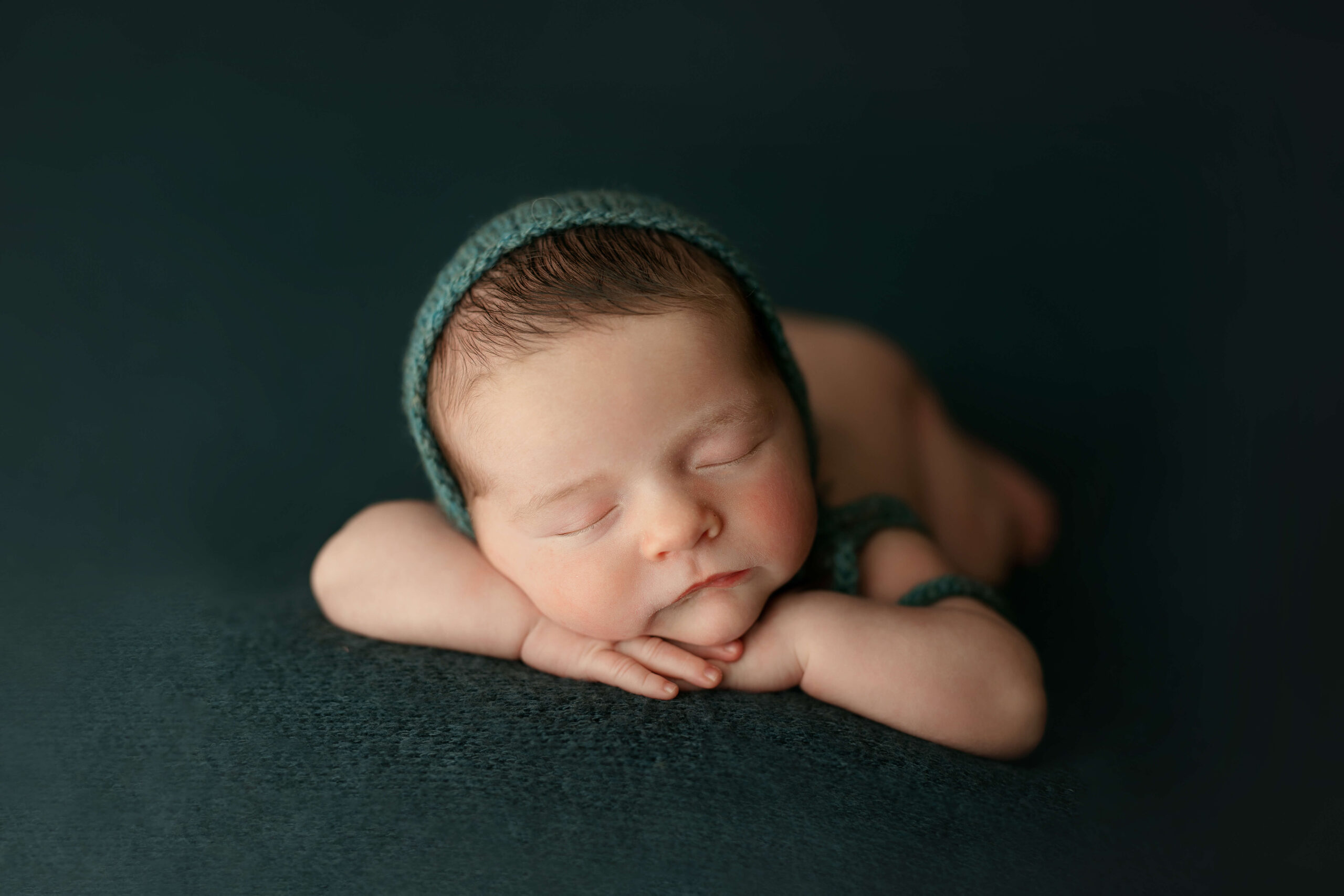 newborn baby laying on his hands at his northern virginia newborn photo session