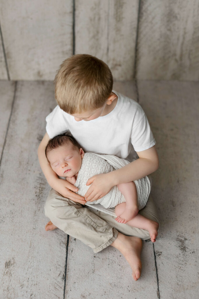newborn being held by his big brother taken by a Northern Virginia Newborn Photographer