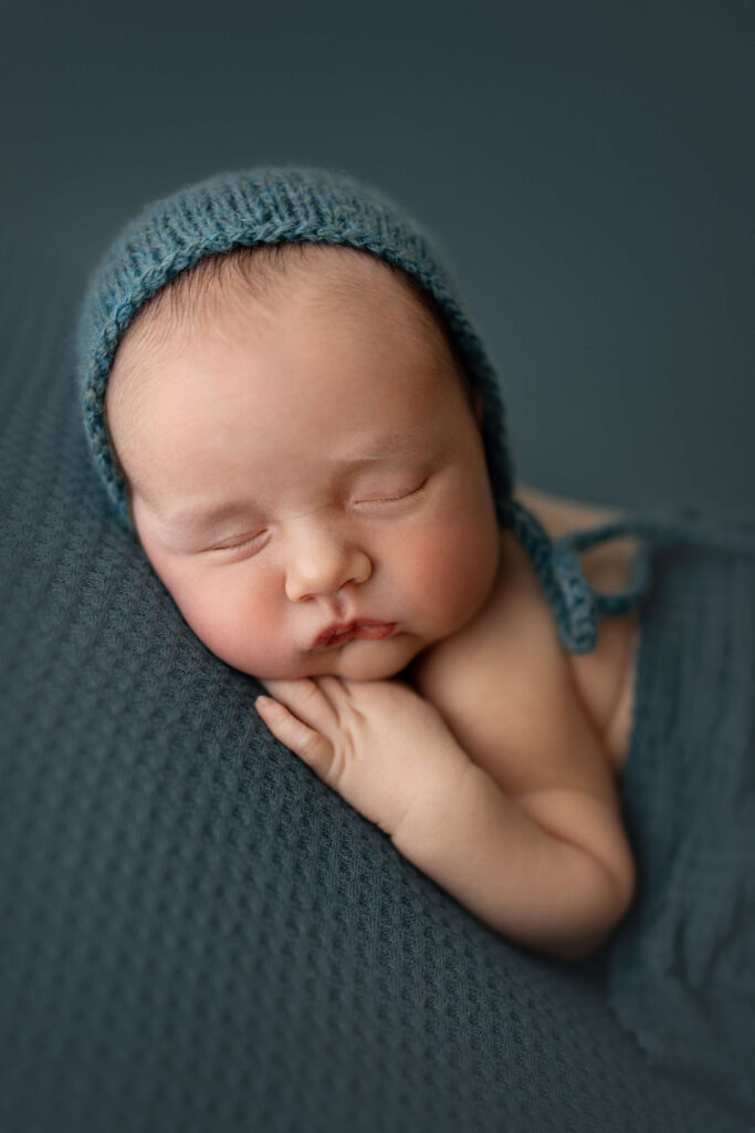 newborn baby with blue bonnet