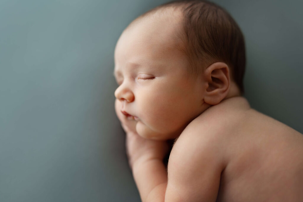 slleping newborn baby on light blue background
