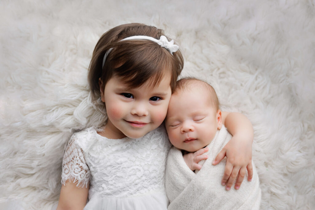 sister holding her newborn brother , dc newborn photographer